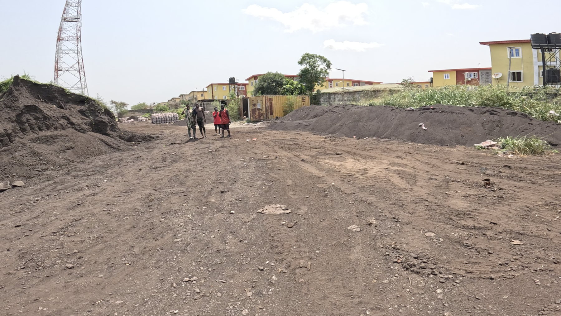 A track of dark earth running between two long spoil heaps